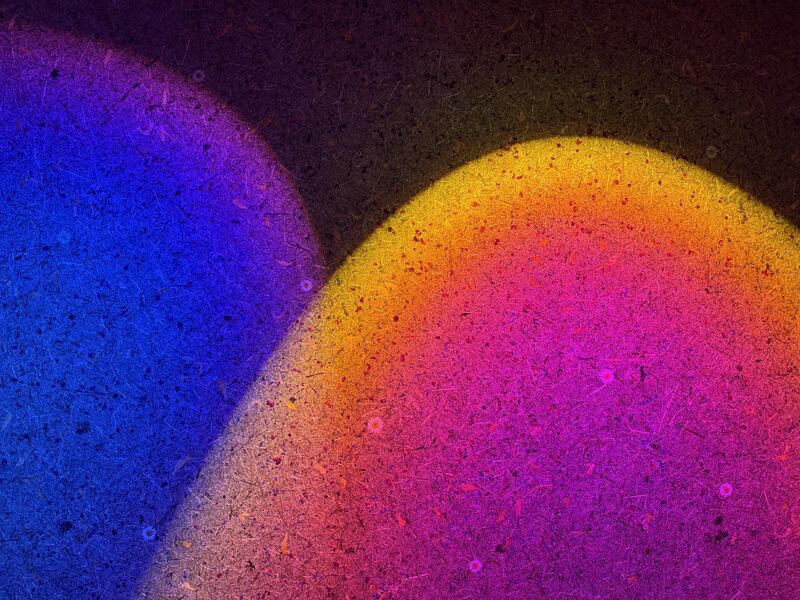 Farbige Lichtprojektionen in Blau, Magenta und Gelb auf strukturierter Oberfläche – Darstellung unterschiedlicher Lichtfarben und ihrer Wirkung im Raum.